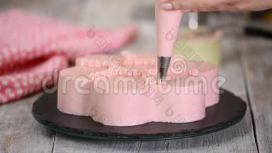 糕点厨师正在做<strong>一个</strong>粉红色的蛋糕，形状像一朵花。 <strong>系列</strong>。